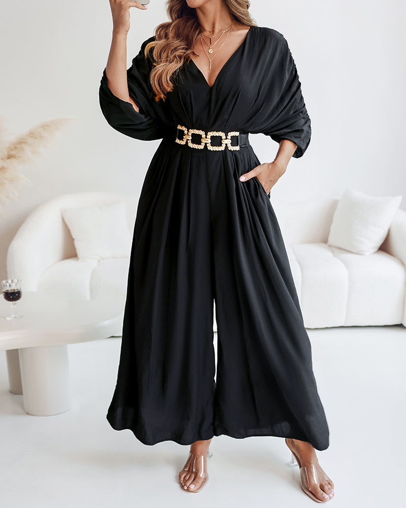 Deep V-neck jumpsuit with ruched sleeves and waist ties in a solid color.