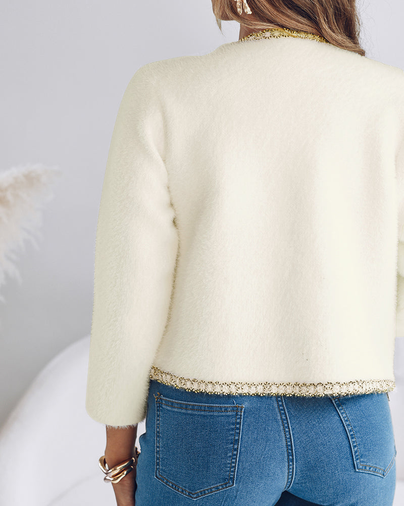 A KOAD'CLO  Pearl Button Fluffy Cardigan with elegant contrast trim and blue jeans.
