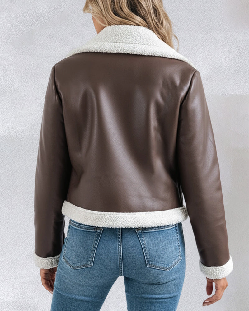 Brown faux leather shearling-trimmed zip-up biker jacket with white trim, light blue fitted jeans.