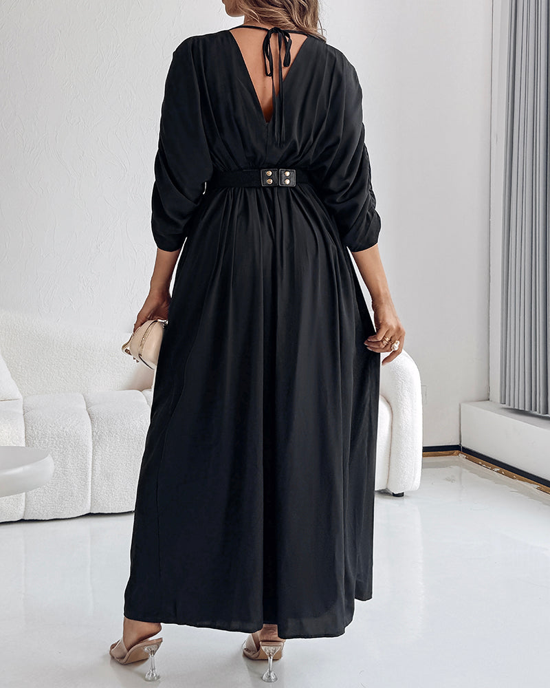A deep V-neck jumpsuit with ruched sleeves and waist ties in a sleek, elegant style.