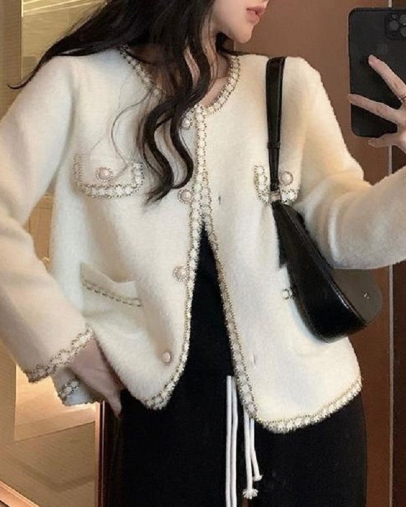KOAD'CLO  Pearl Button Fluffy Cardigan with contrast trim, flap pockets, over black top and pants.