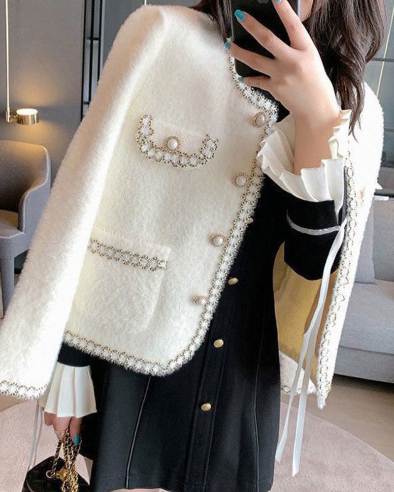 KOAD'CLO Pearl Button Fluffy Cardigan layered over a black dress with ruffled cuffs.