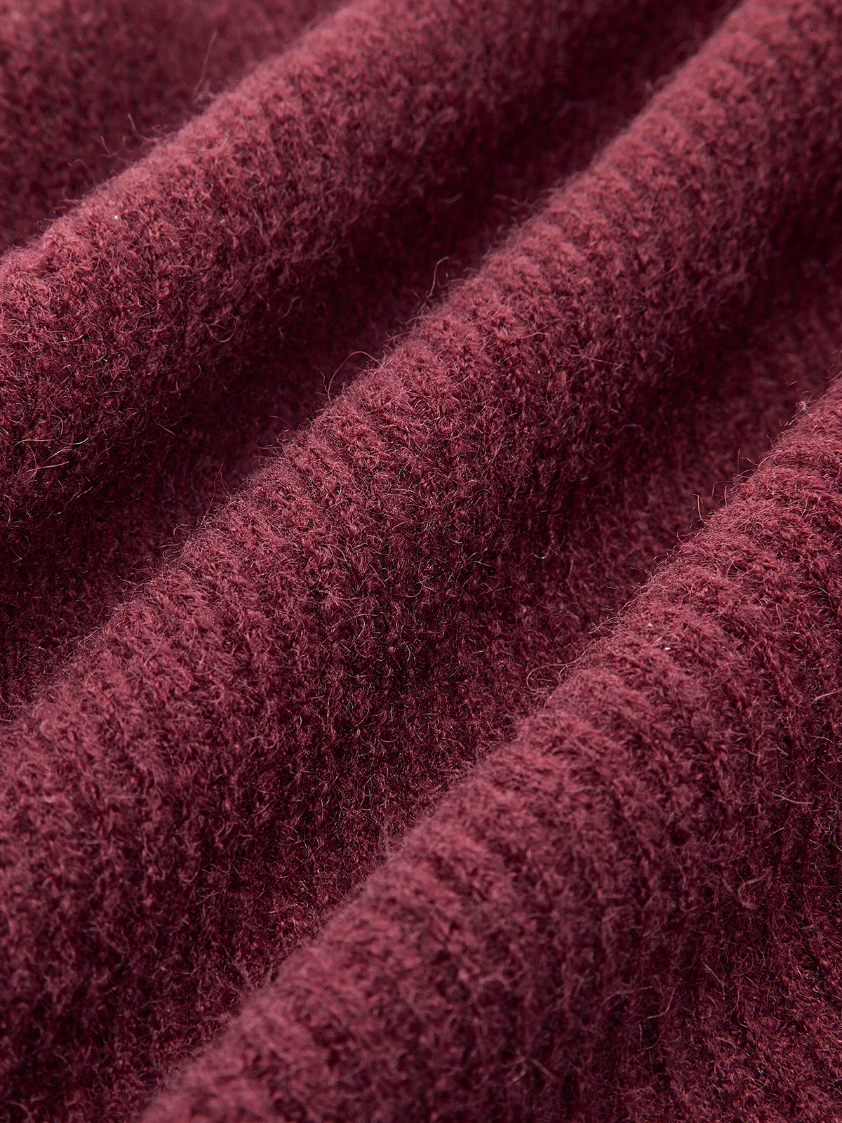Burgundy ribbed cardigan with lace trim, soft fibers, tie-front bow, diagonal ridges.