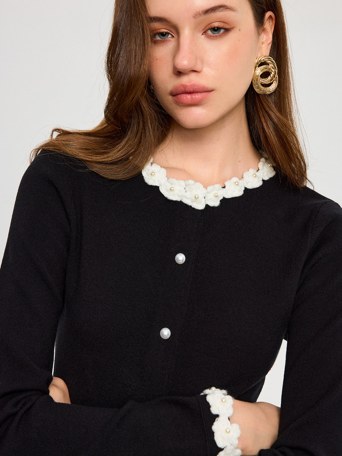 The KOAD'CLO cardigan features 3D floral embroidery and elegant pearl buttons.