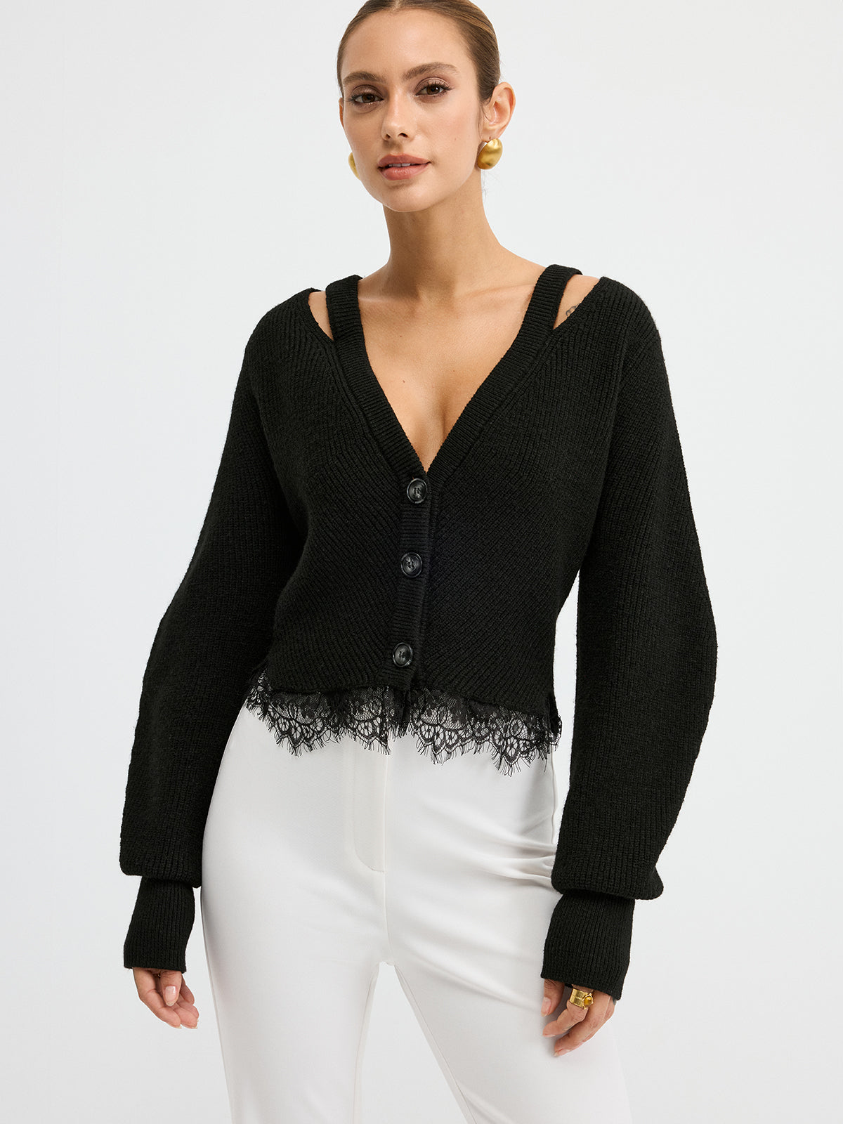 Wool blend cardigan with lace hem, unique shoulder cutouts, paired with high-waisted white pants.