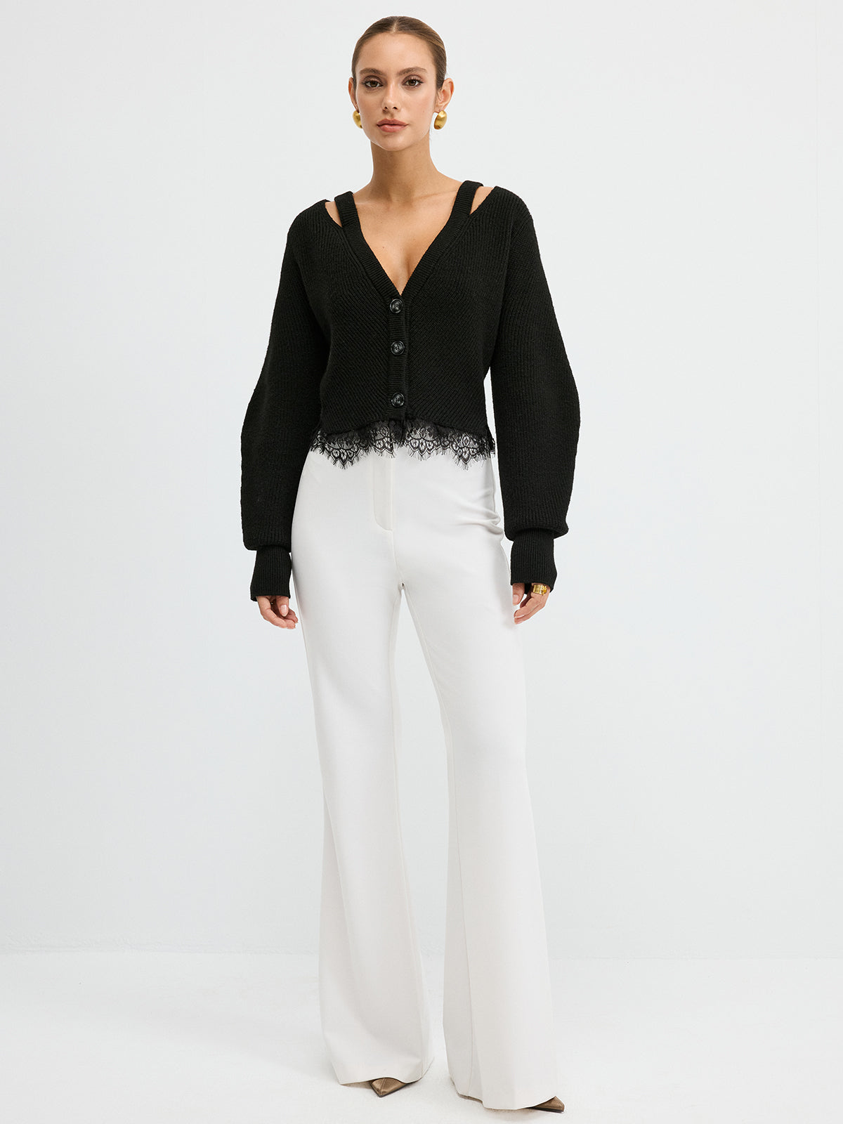 KOAD'CLO wool blend cardigan with lace hem and cutout shoulders, white wide-leg pants.
